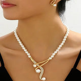 Pearl necklace with a gold clasp on a model against a neutral background