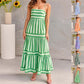 Green and white striped dress worn by a model against a neutral background
